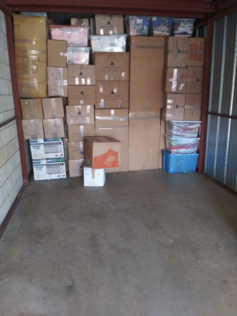 Storage unit packed with boxes and blanket wrapped furniture by Assured Logistics Group in Linden NJ