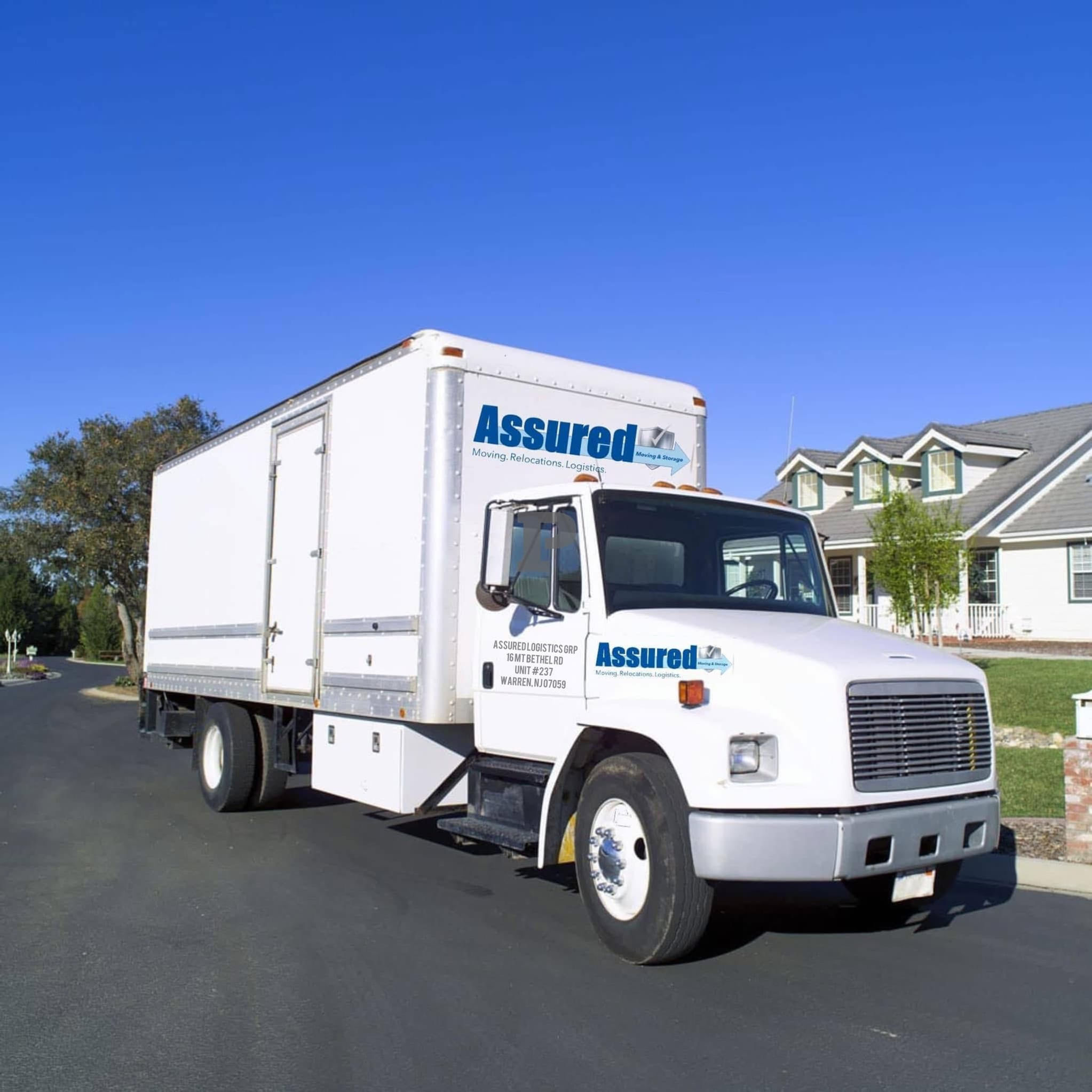 White Assured moving truck driving on a residential street. Central NJ Local Moving Services