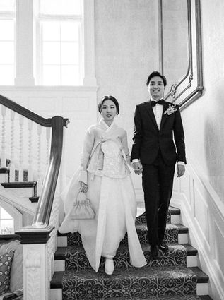A couple walks down the stair case before their reception at Graydon Hall Manor in Ontario.