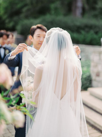 Groom lifting the Brides veil during a wedding ceremony at Paletta Mansion in Toronto.