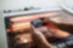 A imagem exibe uma mão segurando um celular que está apontando para uma grande máquina para explicar como a Realidade aumentada pode apoiar em treinamentos e reparos