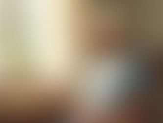 Caregiver sitting peacefully with tea by window, taking essential respite break during demanding holiday season while caring for brain injury survivor