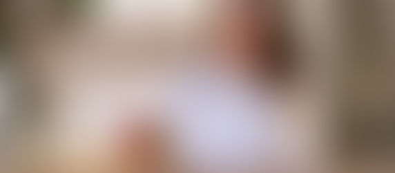 Frau mit weissem Pullover tropft doTERRA Lemonöl in ein Glas Wasser