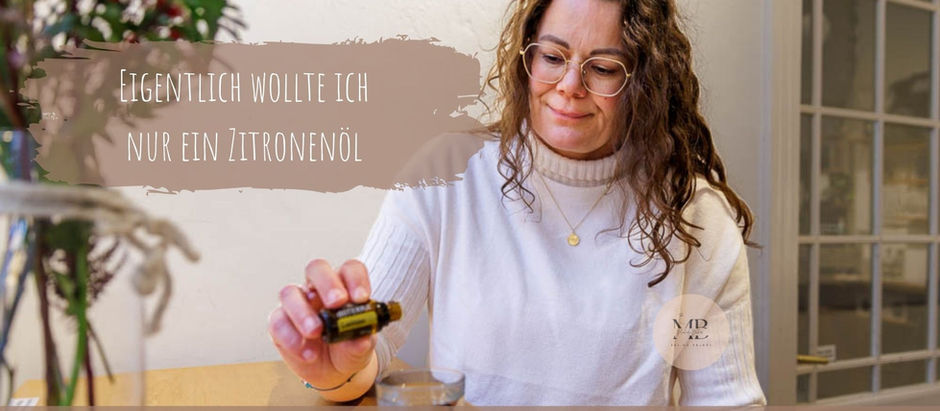 Frau mit weissem Pullover tropft doTERRA Lemonöl in ein Glas Wasser