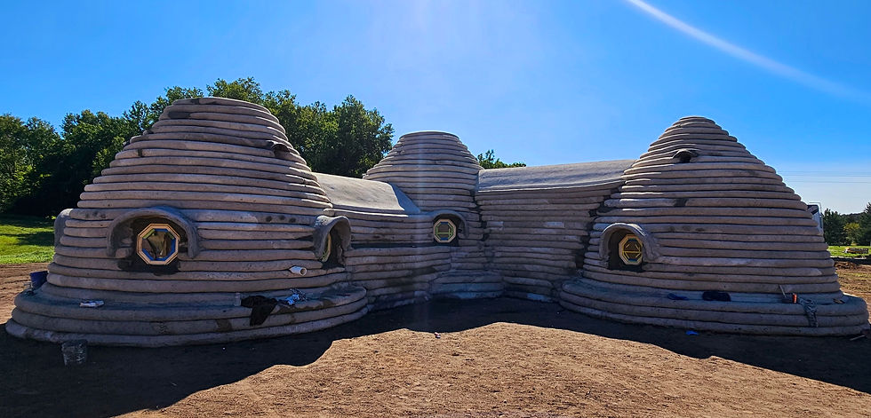 Ground-level view of The Hive dome exterior during construction in Luther, Michigan