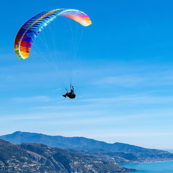 Paraglider in the sky with lake in the background