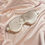 Thumbnail: A large ivory white mulberry silk eye mask against a pale pink silk background