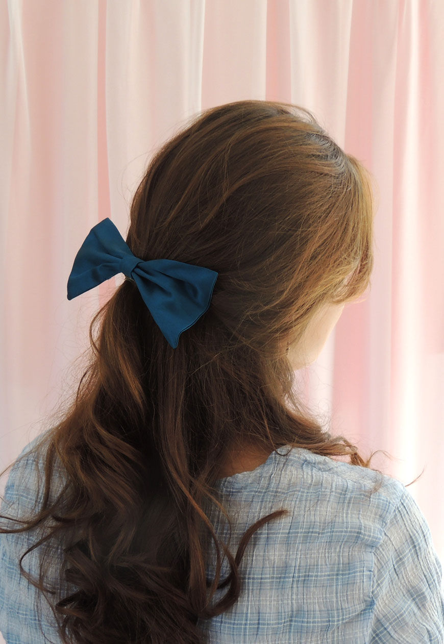 Thumbnail: Woman wearing a teal silk hair bow without tails