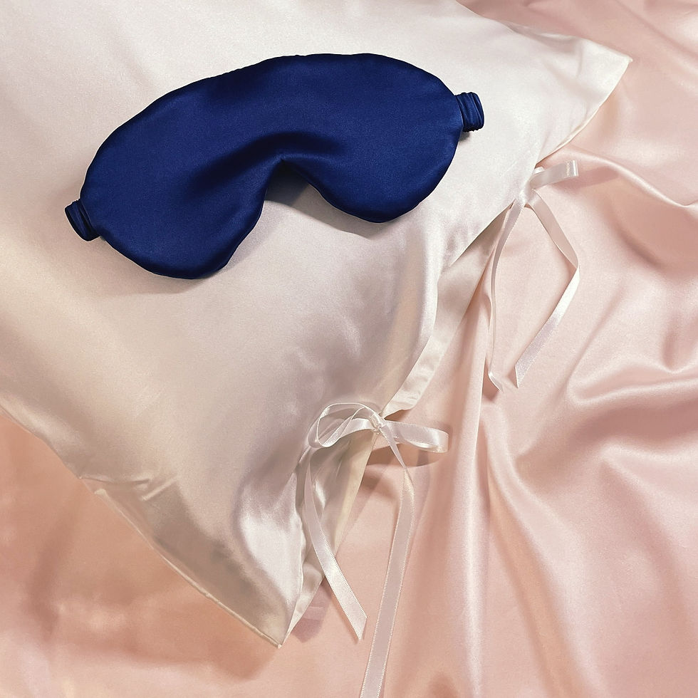A large navy blue mulberry silk eye cover on a white silk pillowcase
