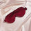 Thumbnail: A large red mulberry silk sleep mask against a pale pink silk background