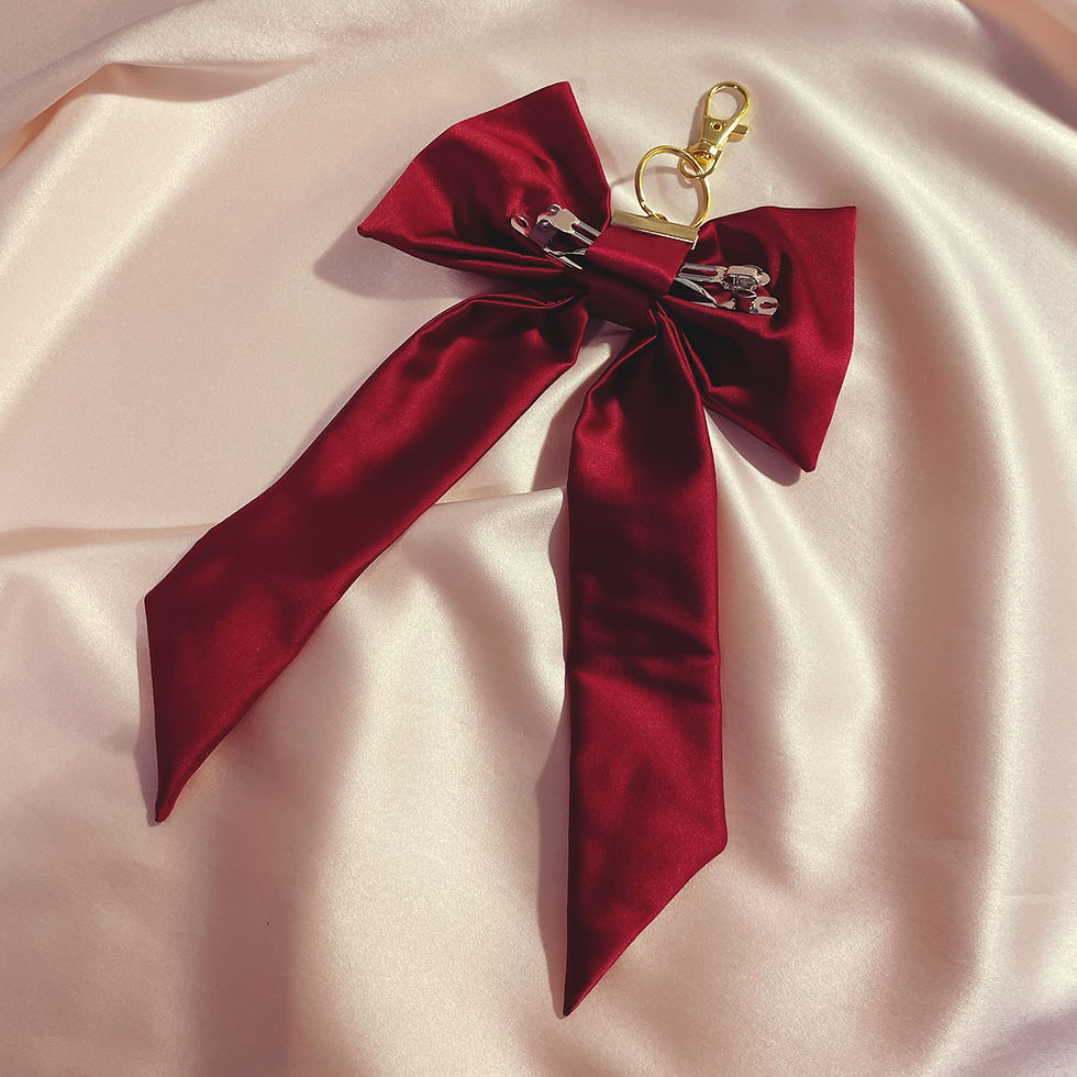 Thumbnail: The reverse of a red silk bow bag charm with metal barrette clip