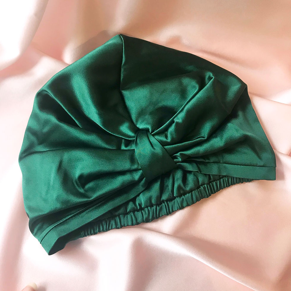 Deep green silk sleeping bonnet on a pale pink silk background