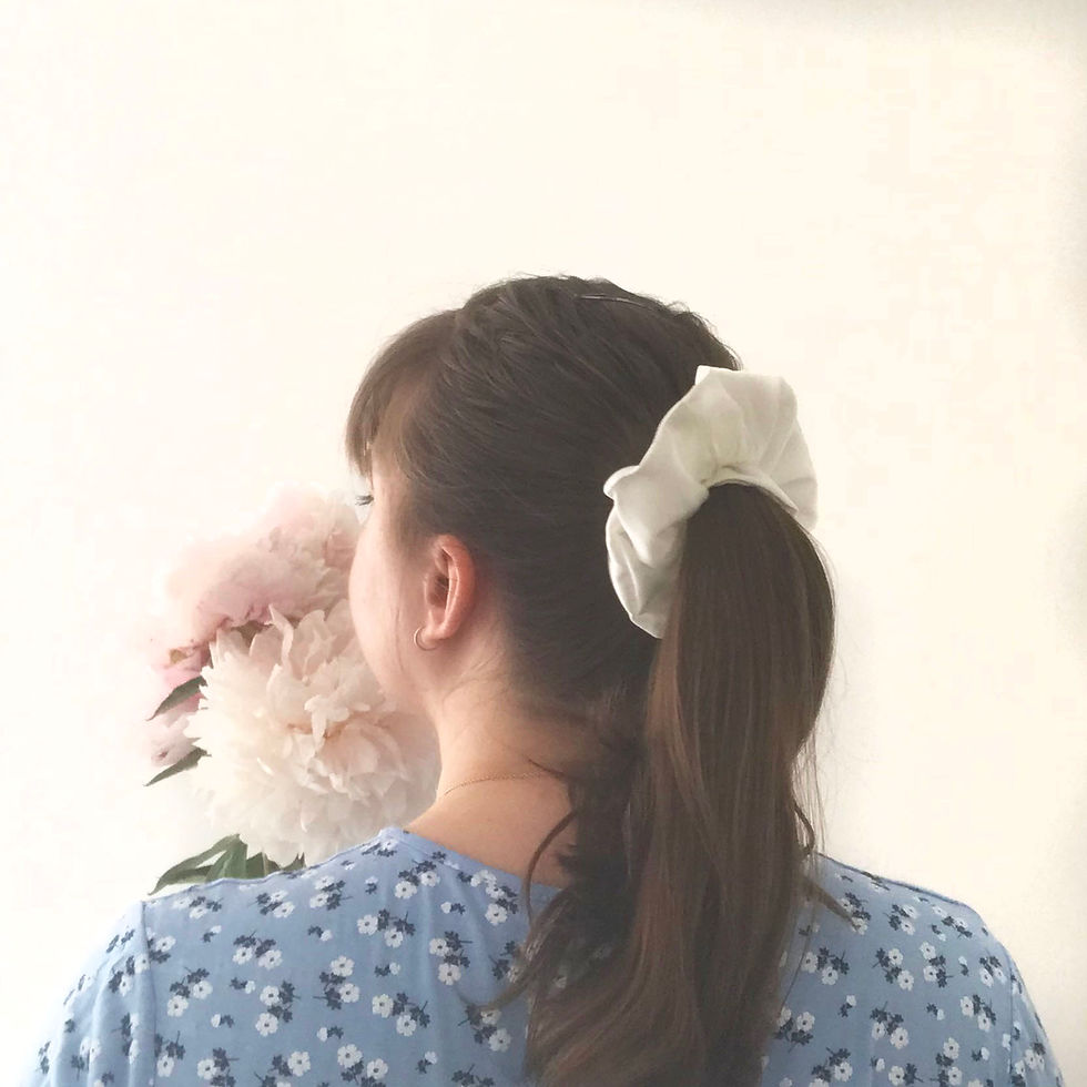 Thumbnail: A woman facing away from the camera with brown hair in a ponytail with white silk scrunchie