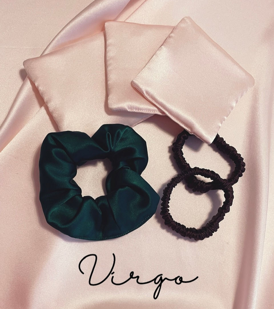 three silk face pads in pale pink, a deep green silk scrunchie and two black silk hair elastics against a pale pink silk background with Virgo text