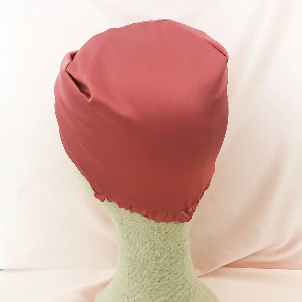 Thumbnail: A mid pink silk sleeping bonnet on a mannequin head against a pale pink silk background