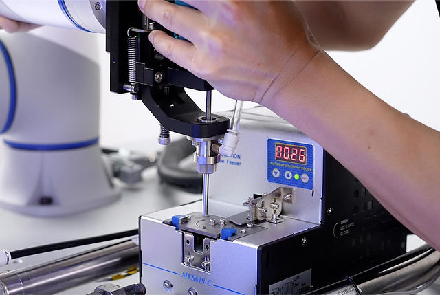 Robot Dobot współpracuje z automatycznym podajnikiem śrub podczas procesu wkręcania