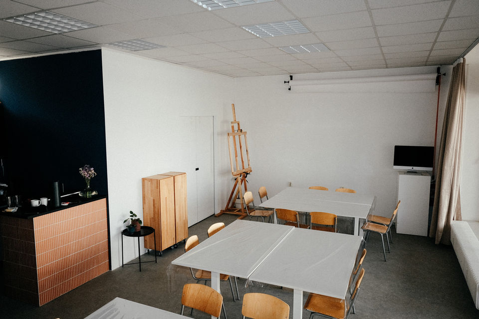 Oficina Space Of Hearts com mesas com altura ajustável e 24 cadeiras para colaboração artística.