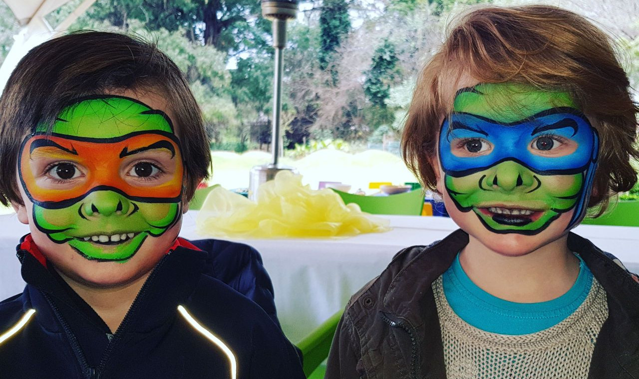 Two boys with ninja turtles face paint at a party in johannesburg