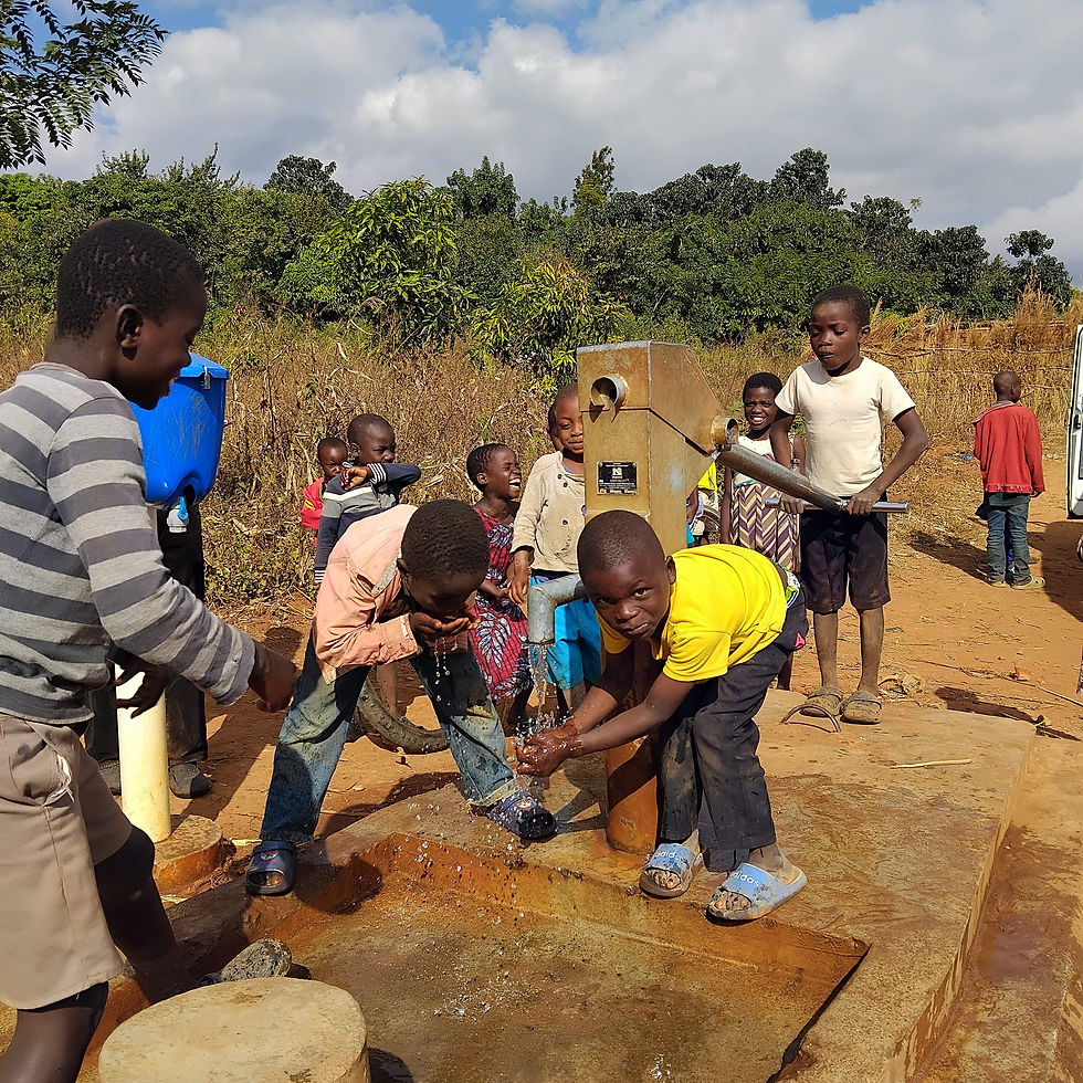 Children enjoying clean water from the repaired hand pump