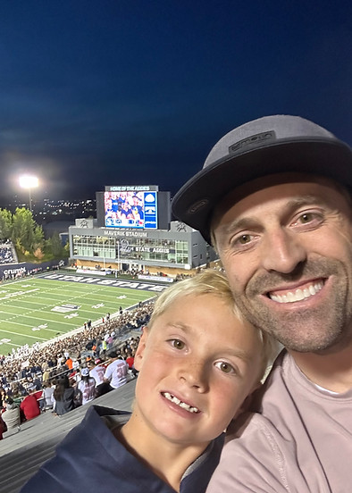 Father and son cheering at Utah State Aggies game - Steven Hanson supports Cache Valley families
