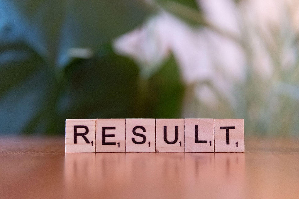 Wooden blocks spelling RESULT on a tabletop, with a soft blurred floral background and warm, calm tones.