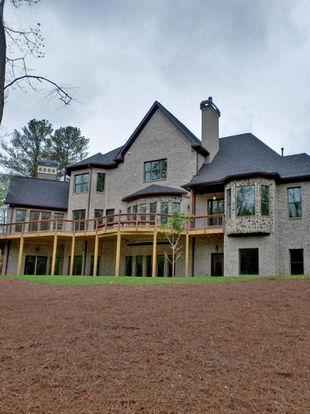 the back of a large brick house with a large deck