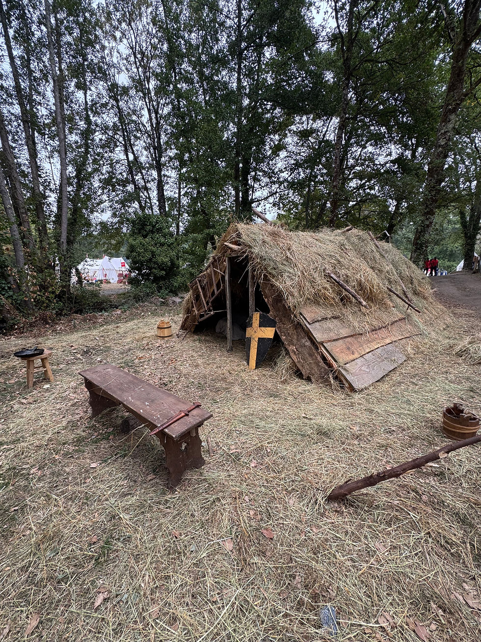 Vue sur la tente faite de planches en bois et de végétaux (foin et branches plessées)