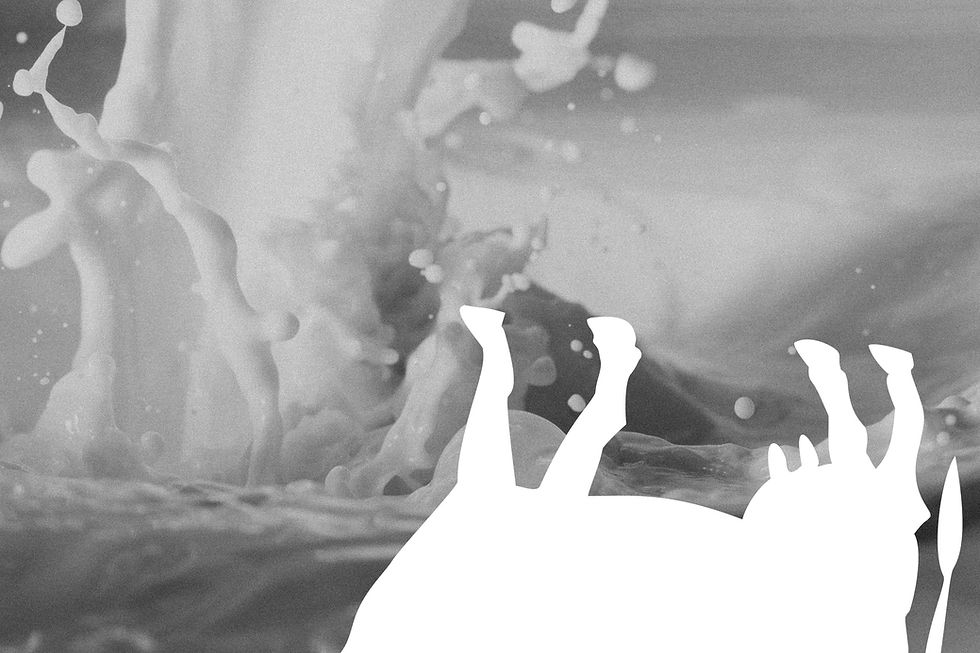 The image is of an upside down cow over a background of milk