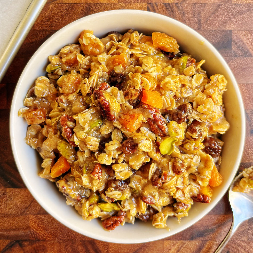 A bowl of granola breakfast cookie dough beside a baking sheet lined with parchment paper.