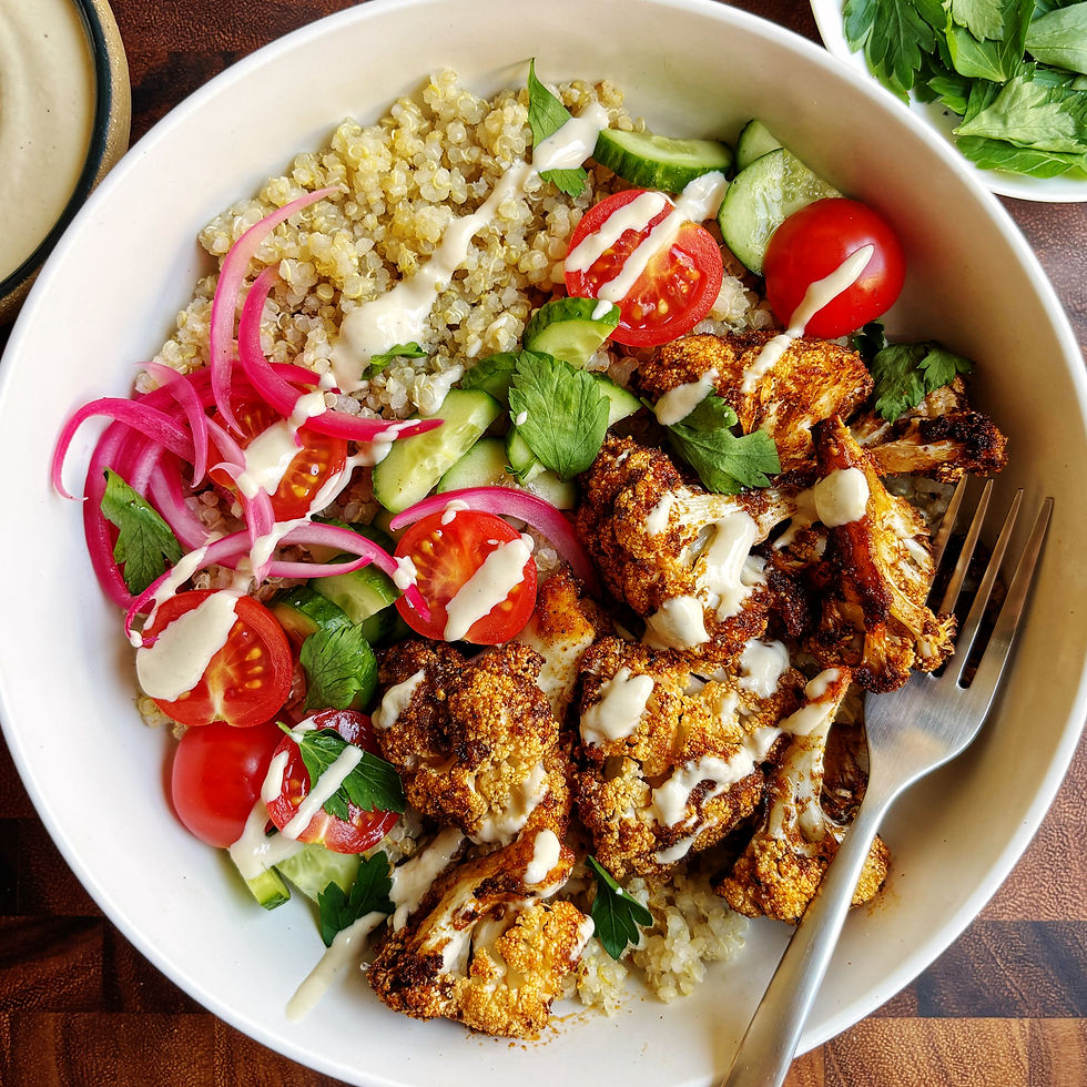 Cauliflower "shawarma" bowls with tomatoes, cucumbers, pickled onions, quinoa, and garlic tahini sauce.