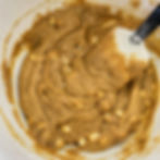 Tahini blondie batter in a bowl with a spatula.