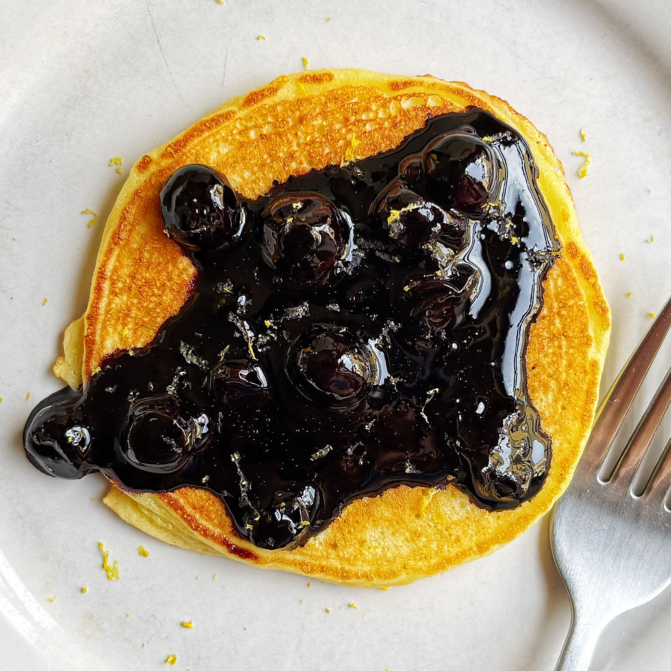 Cottage cheese pancake topped with blueberry sauce on a plate.