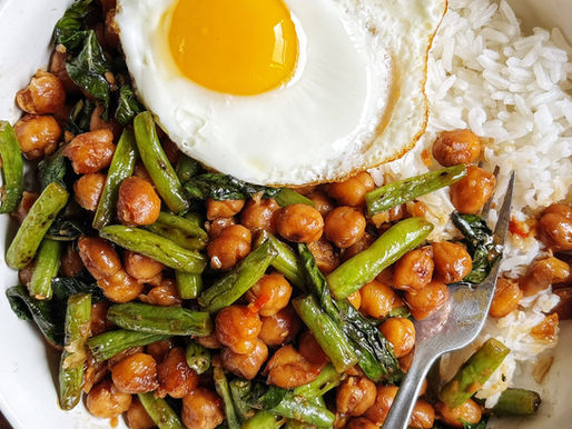 Thai basil chickpeas in a bowl with rice, topped with a fried egg.