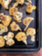 Charred cauliflower on a baking sheet.