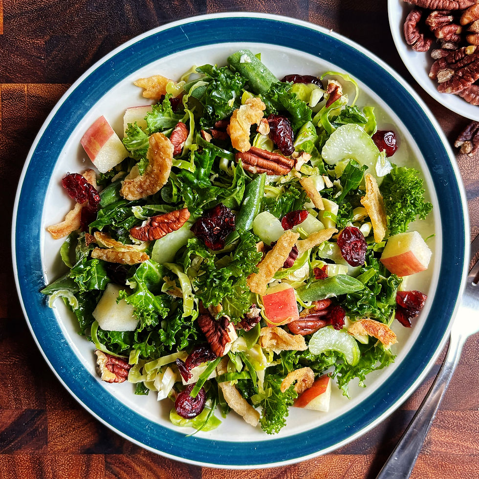 Day-after-Thanksgiving crunch salad with kale, shredded brussels sprouts, celery, green bans, apples, pecans, cranberries, and fried onions on a plate.
