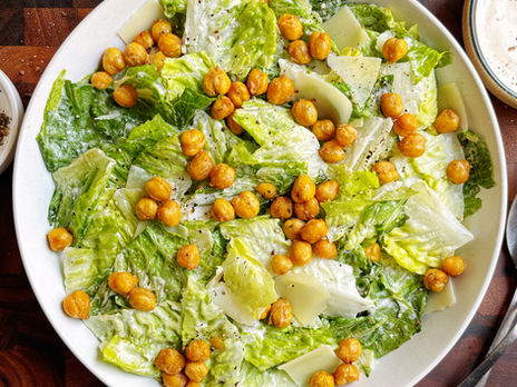 Crispy chickpea caesar salad topped with crispy chickpeas, shaved parmesan, and black pepper. 