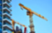 Yellow mobile crane on large building site and   under construction high-rise building wit