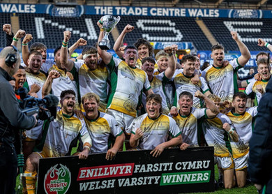 close up of Swansea University mens rugby team celebrating together, holding up the Varsity winners cup