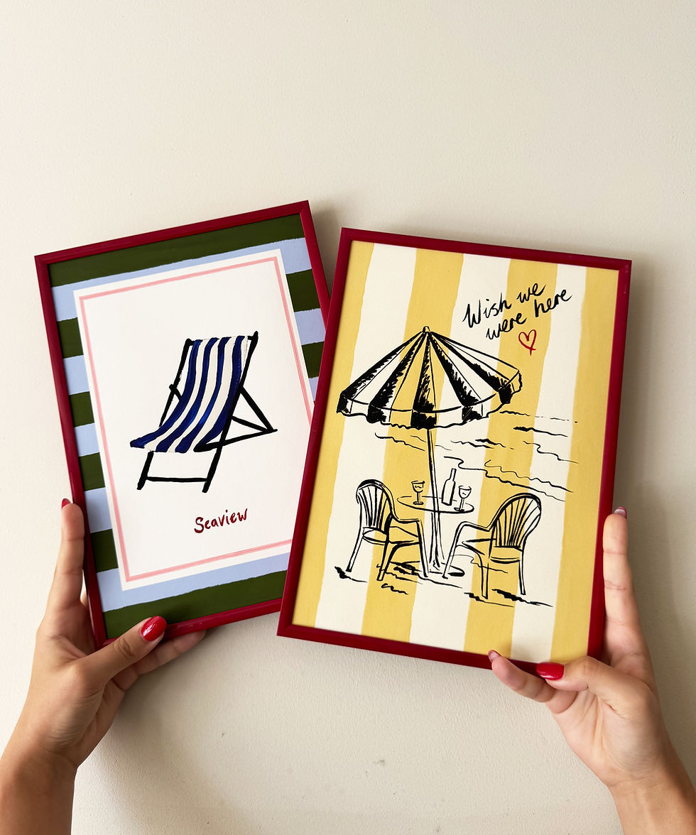 Thumbnail: "Wish We Were Here" ink sketch print of a beach parasol and plastic chairs on a striped background, seaside wall art in frame