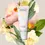 Miniaturbild: Noelie Scalp & Hair Detox Mask vor einem floralen Hintergrund mit natürlichen Inhaltsstoffen wie Rose, Ringelblume und Salbei