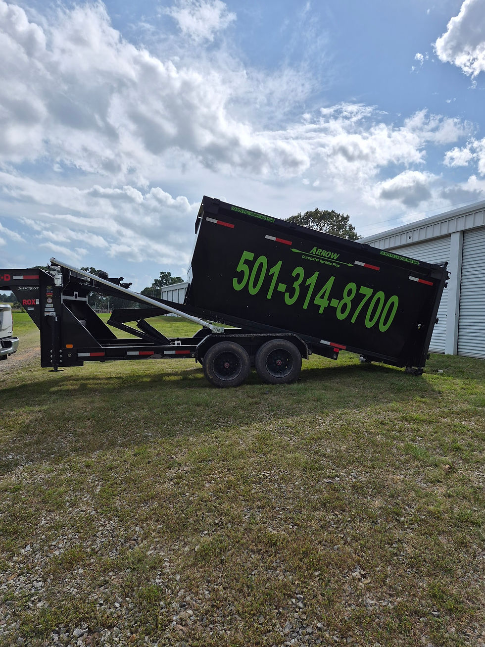 Cabot Arkansas black dumpster trailer tilted on grass beside a building, with green 501-314-8700 on the side under a cloudy sky.