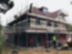 Builders working on scaffolded house