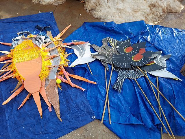 Signs and crafts laid out on a blue tarp.
