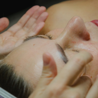 Close-up of a woman receiving a gentle facial massage during a skincare treatment.