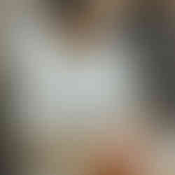 Woman with glasses giving a relaxing facial treatment in a skincare salon.