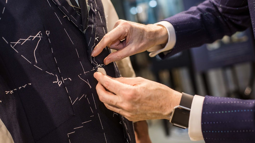 Tailor adjusts blue pinstripe suit with white stitching patterns. Hands focus on precision work, creating a professional and meticulous mood.
