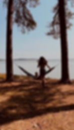 Woman running to hammock setup by the water