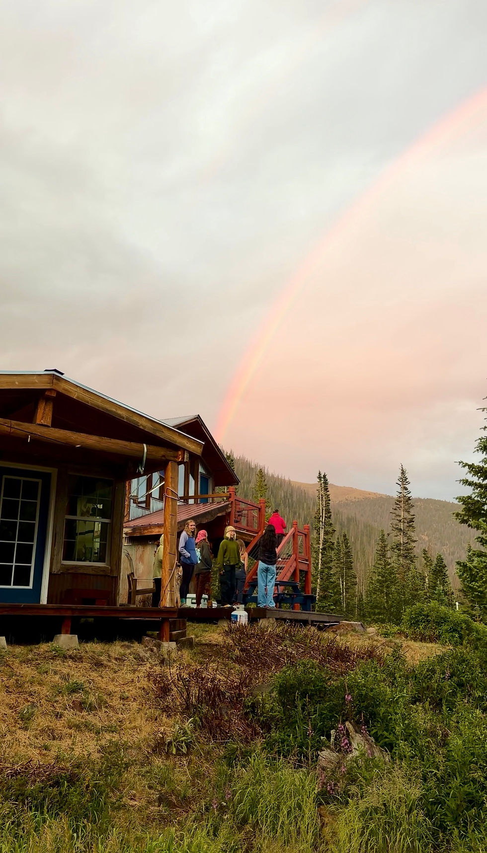 Women admiring a rainbow at backcountry hut trip