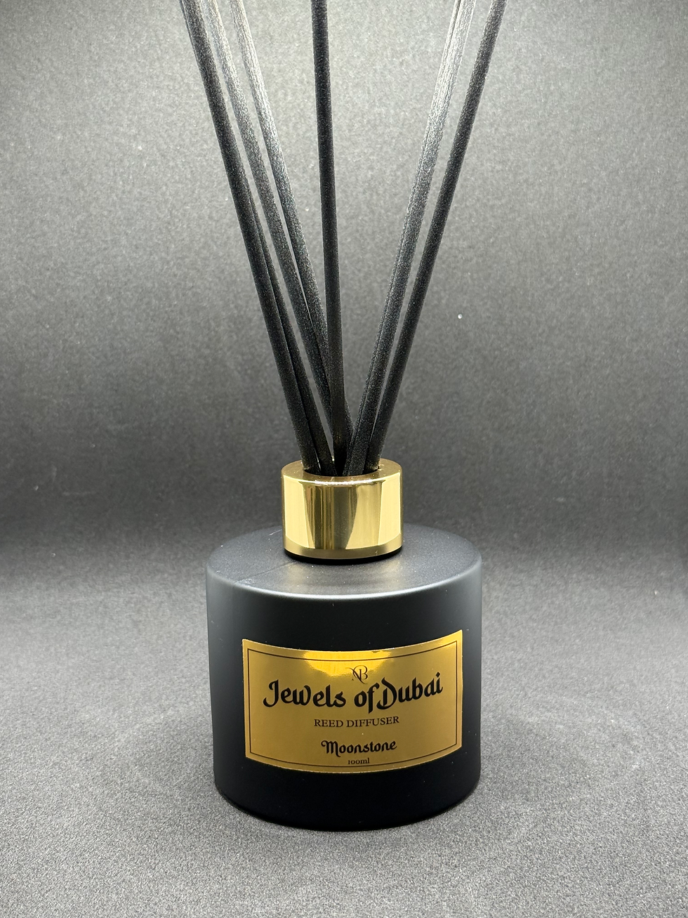 A reed diffuser in black jar with gold label