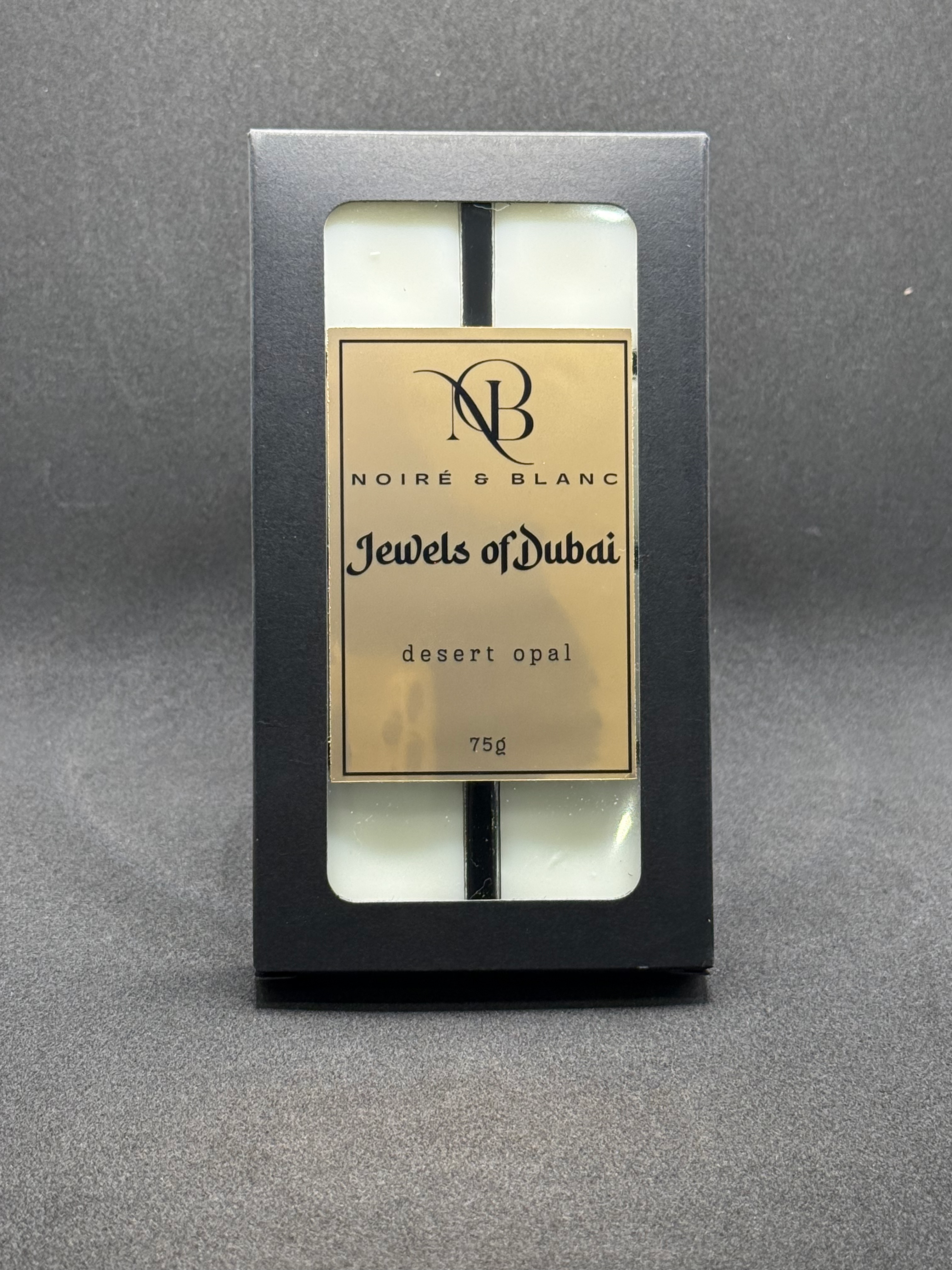 A black box of wax melts with a gold label